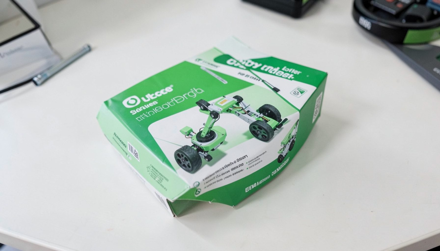 A neatly packaged robotics starter kit with green and white branding on a clean desk surface